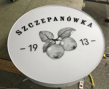 Okrągłe logo z podświetleniem LED z plexi i taśmy alu.