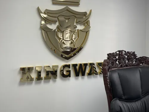 Złoty lustrzany znak tarczy z koroną i napis Kingway na jasnej ścianie za ozdobnym fotelem.