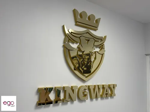 Zbliżenie złotego lustrzanego znaku z koroną i liter przestrzennych Kingway.