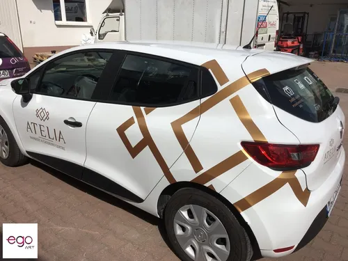 Złota grafika Atelia na białym Renault Clio