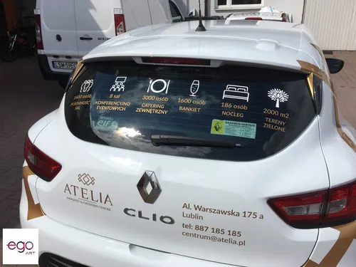 Logo i oferta Atelia na tylnej szybie Renault Clio