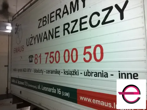 Napisy o zbiórce używanych rzeczy na kontenerze Emaus