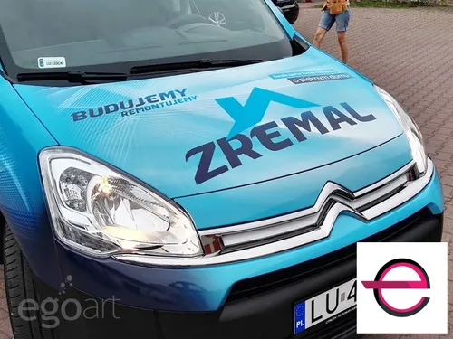 Logo Zremal na masce turkusowego samochodu