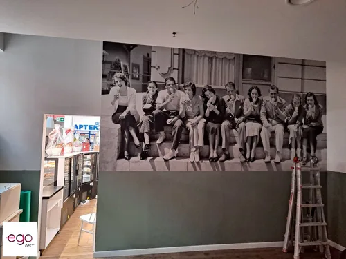 Czarno-biała fotografia grupowa na ścianie cukierni