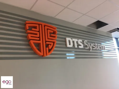 Zbliżenie pomarańczowego znaku i białych liter 3D DTS System z ciemnymi bokami.