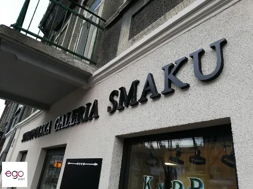 Litery przestrzenne z matowym czarnym licem z alubondu nad witryną lokalu.