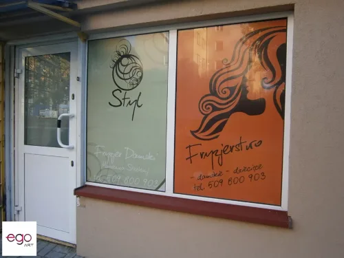 Witryna salonu fryzjerskiego z kolorową grafiką