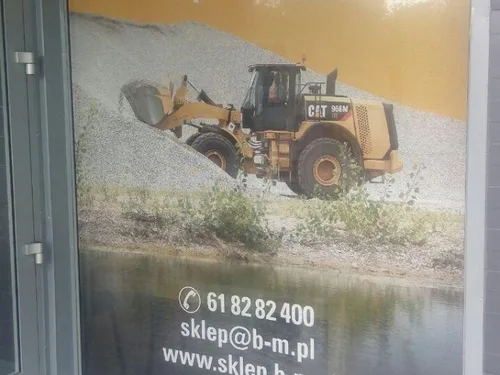 Grafika z maszyną budowlaną na folii okiennej