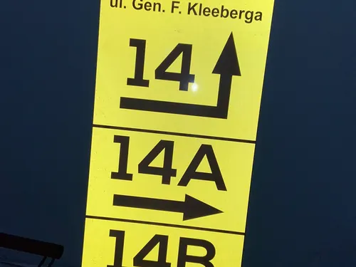 Żółta tablica kierunkowa z folią odblaskową przy ul. Gen. F. Kleeberga, z numerami 14, 14A i 14B, oświetlona w ciemnym otoczeniu.