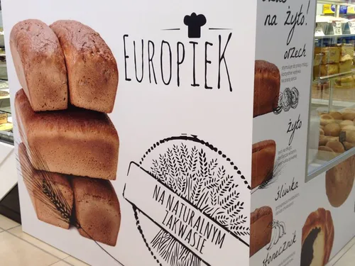 Plansza z PCV z nadrukiem pieczywa, logo Europiek i rysunkami dekoracyjnymi.