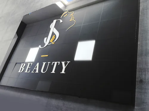 Błyszczący czarny szyld ze złotą grafiką i napisem Beauty.