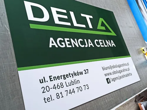 Zielono-biała tablica agencji celnej Delta z logo i informacjami kontaktowymi.