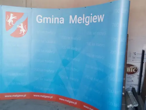 Niebieska ścianka promocyjna Gminy Mełgiew
