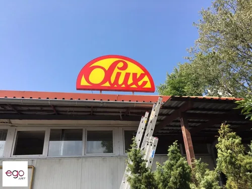 Półokrągłe logo Lux zamontowane nad dachem