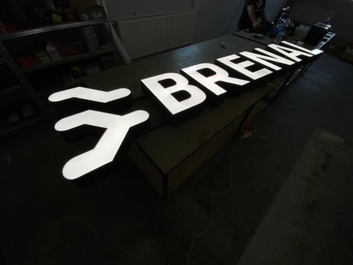 Podświetlane litery przestrzenne 3D BRENAL z białym licem i ciemnymi bokami podczas próby świecenia w pracowni.