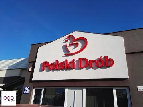 Czerwone logo Polski Drób na białym panelu elewacyjnym