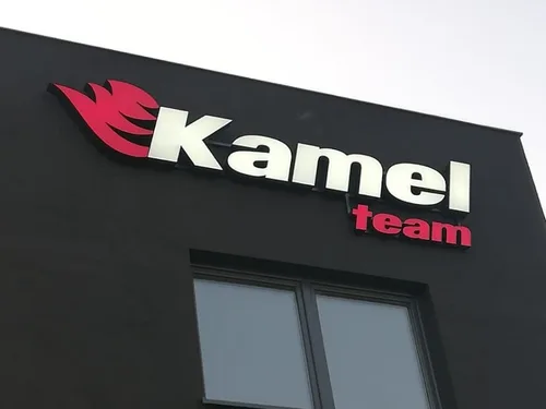 Przestrzenne logo Kamel Team na ciemnej elewacji