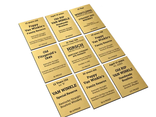Dziewięć złotych tabliczek z laminatu z czarnym grawerem i napisami opisowymi, ułożonych w trzech kolumnach.