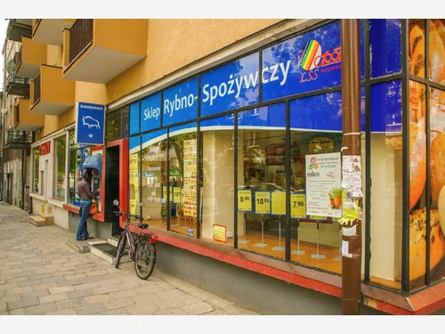 Witryna sklepu spożywczego z grafiką widoczną przez szkło
