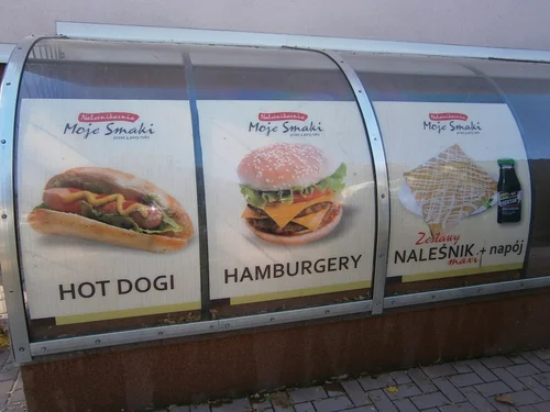 Reklama hot dogów i hamburgerów na zaokrąglonej witrynie